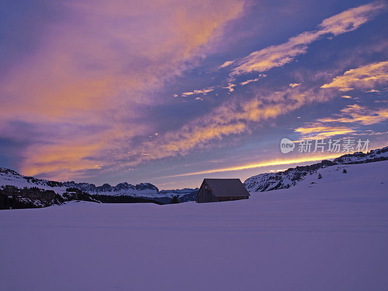 黎明时分，白雪皑皑的高山上空布满了红云