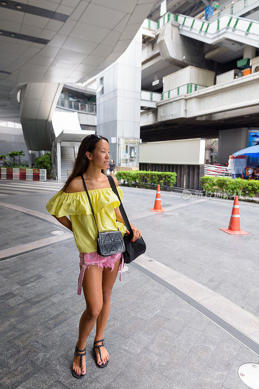 年轻美丽的多民族旅游妇女肖像在商场外的城市曼谷泰国