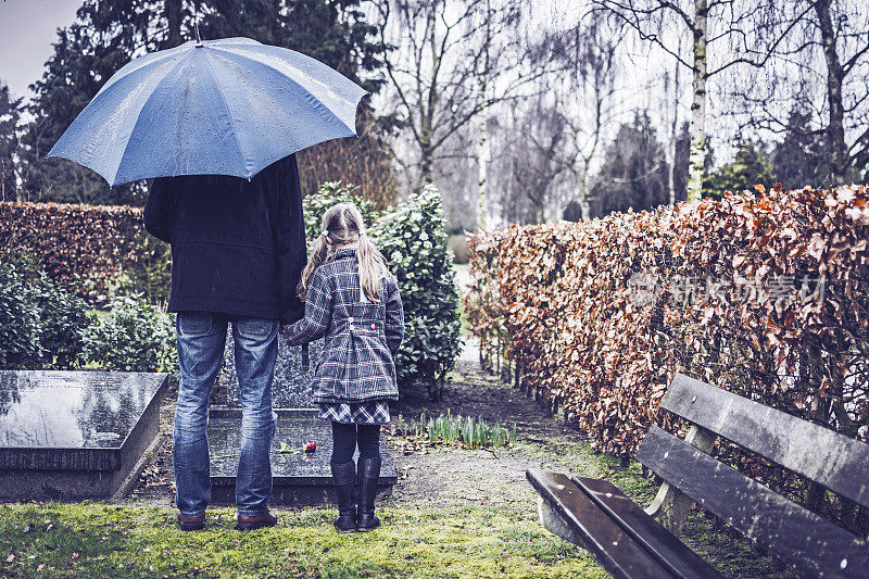 父亲和女儿拜访已故母亲的墓碑