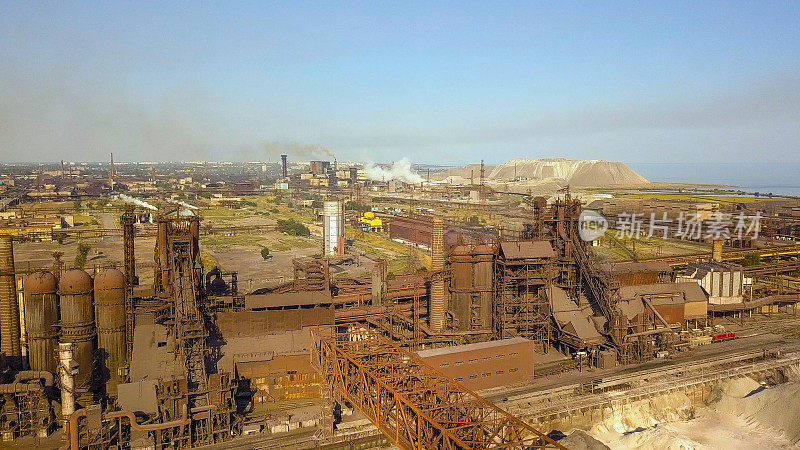 工业钢铁厂鸟瞰图。天线采用工厂。飞过烟雾缭绕的钢铁厂管道。环境污染。烟