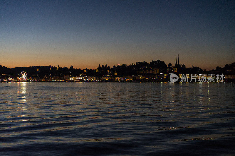日落在卢塞恩湖从船与城市背景