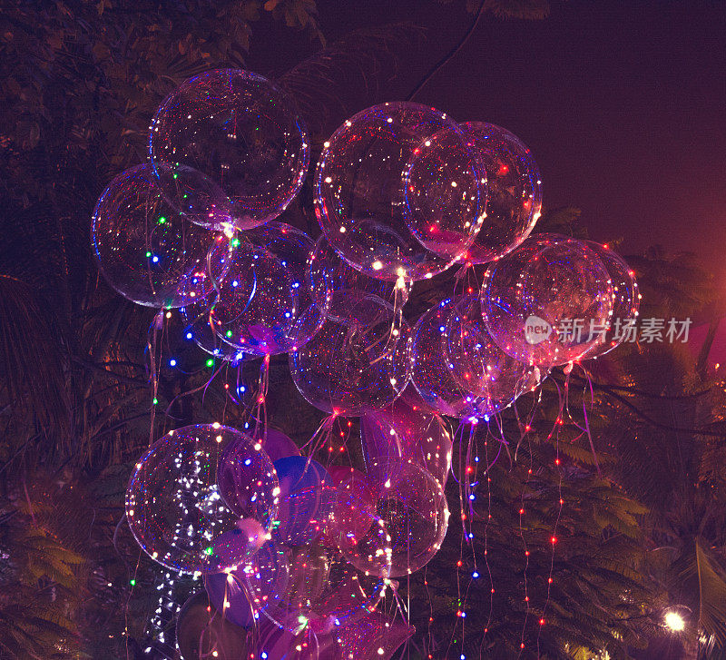 漂亮的凝胶气球，彩灯和灯泡。在晚上