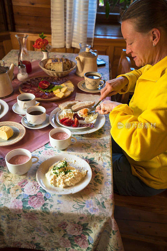 在斯洛文尼亚阿尔卑斯全景公路上享用传统早餐的女人