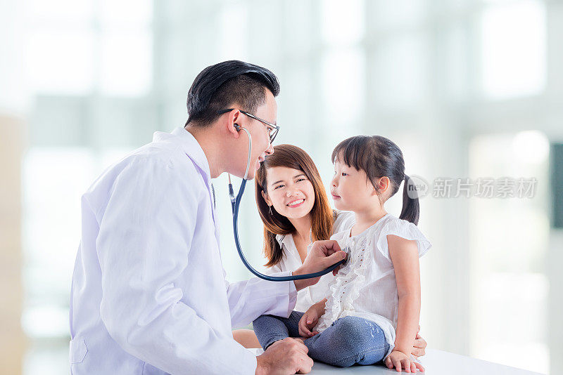 亚洲医生正在用听诊器检查一个女孩