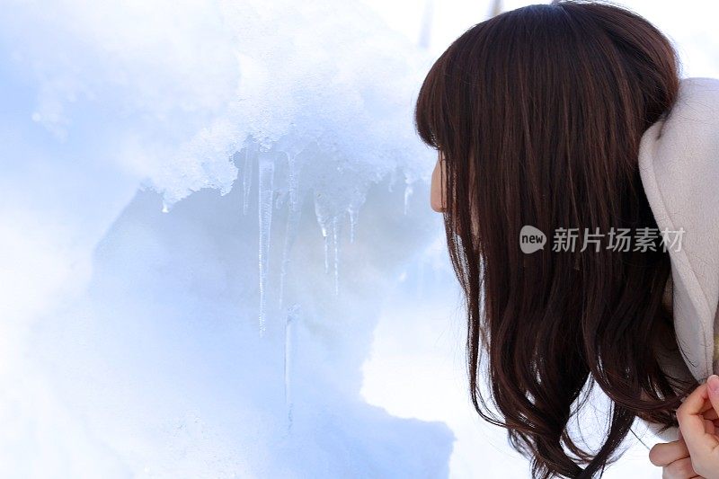 一个年轻女子从堆积的雪中出现