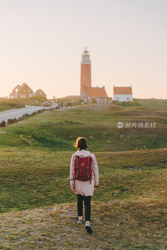 日落时分，Texel岛灯塔附近的女人