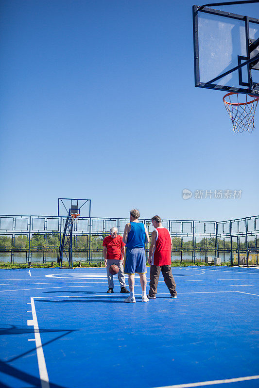 一群老年人在户外进行体育活动，打篮球