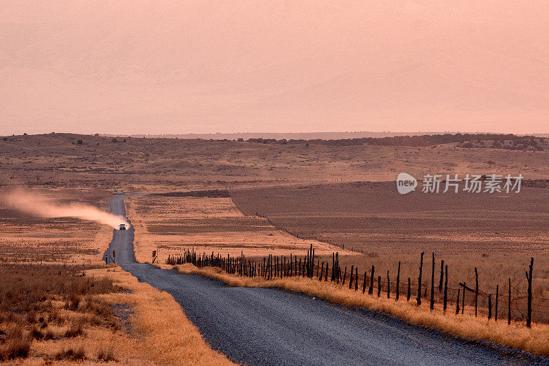 荒凉的乡村泥土和砾石路在一个朦胧的黄昏沙漠