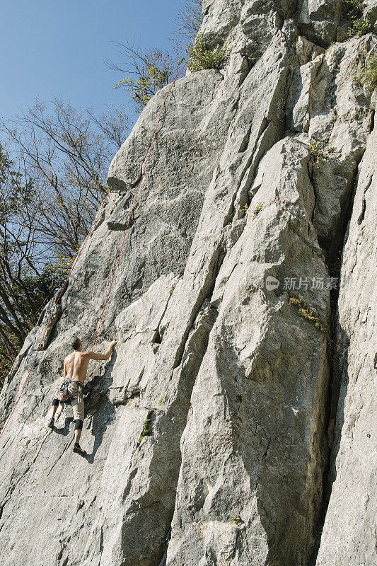 一个人安全地爬着岩壁