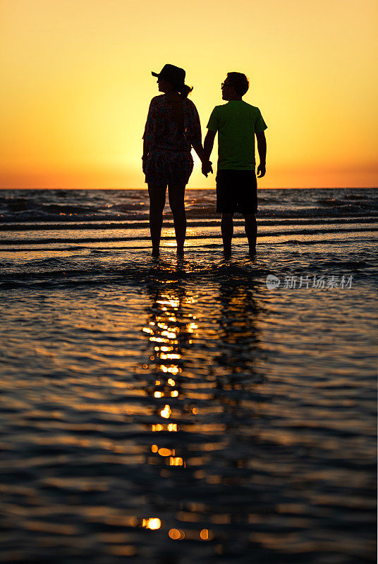 母亲和儿子在佛罗里达的海滩上看日落