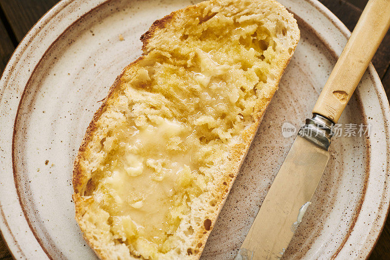 一片烤酸面包，配上融化的黄油和蜂蜜。