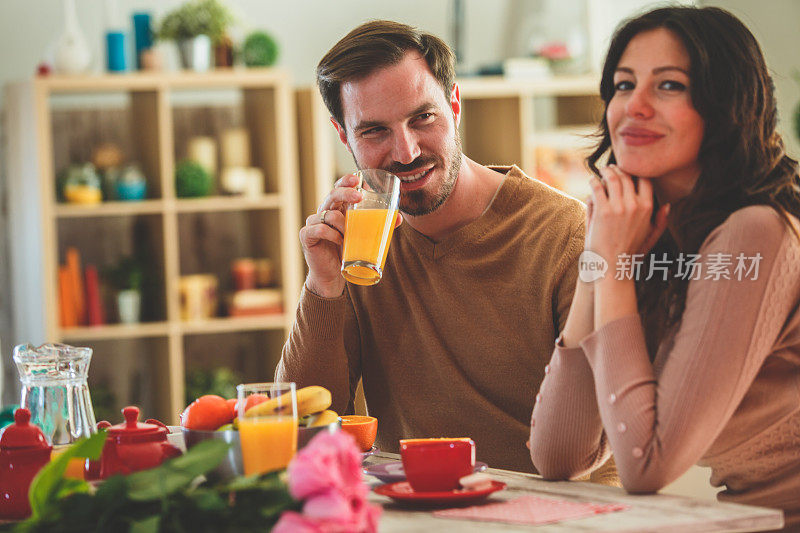 一对夫妇在家里喝咖啡和果汁