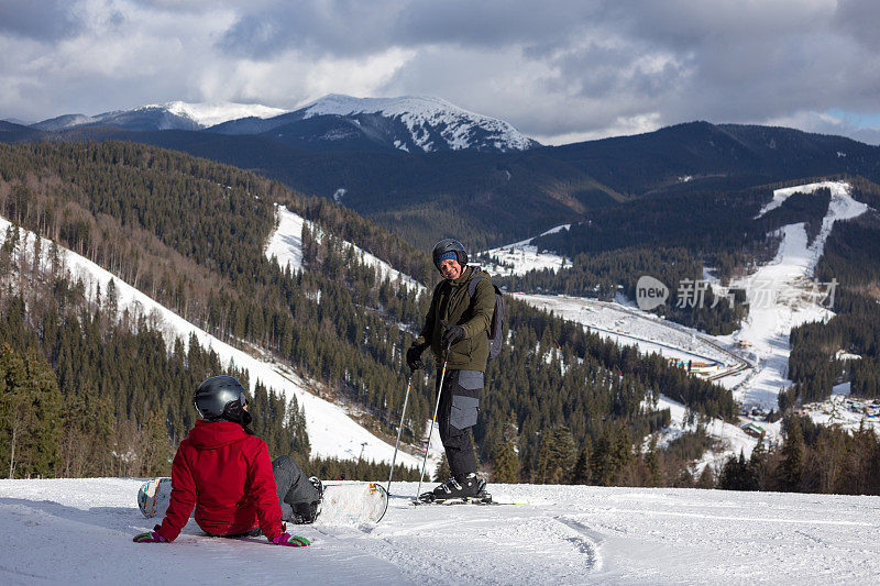 小伙子们在滑雪坡上停下来欣赏山景。