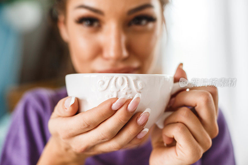 年轻女子一边喝茶一边放松