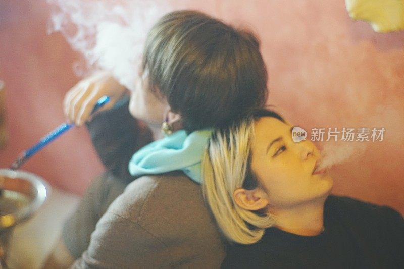 两个年轻的男男女女在抽水烟