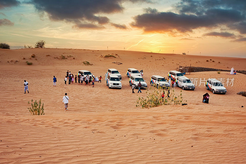 在阿联酋迪拜传统的沙漠探险结束后，游客们把吉普车停在贝都因人营地