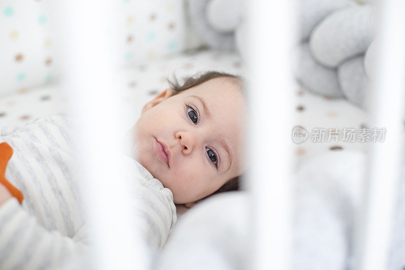 小女孩在她的婴儿床里玩耍