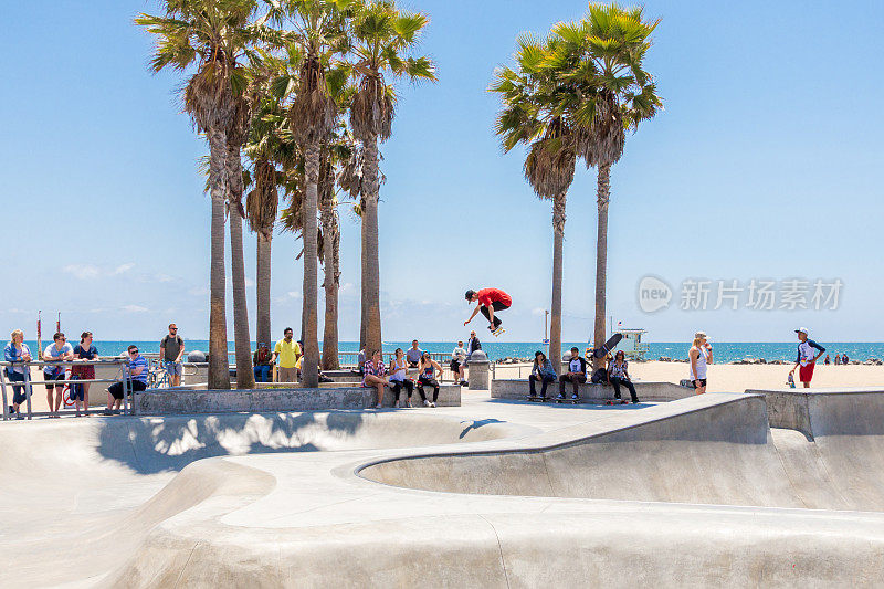 滑板男孩在加州洛杉矶威尼斯海滩的滑板公园练习。威尼斯海滩是洛杉矶最受欢迎的海滩之一