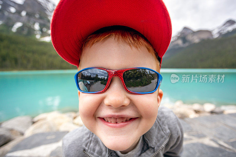 年轻可爱的红发男孩在路易斯湖的特写，班夫，加拿大