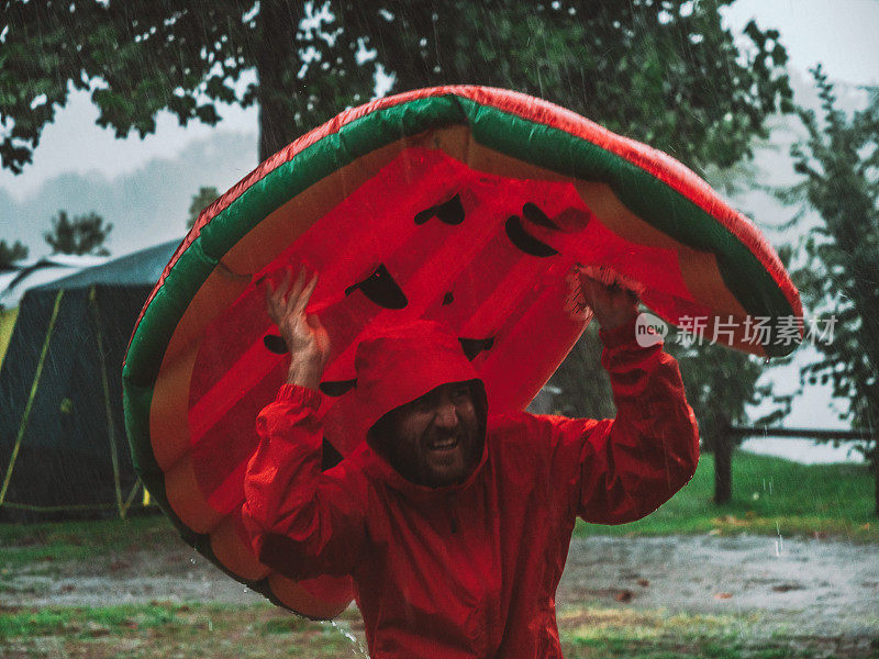 一名男子在露营时被困在暴风雨中，用充气木筏盖住