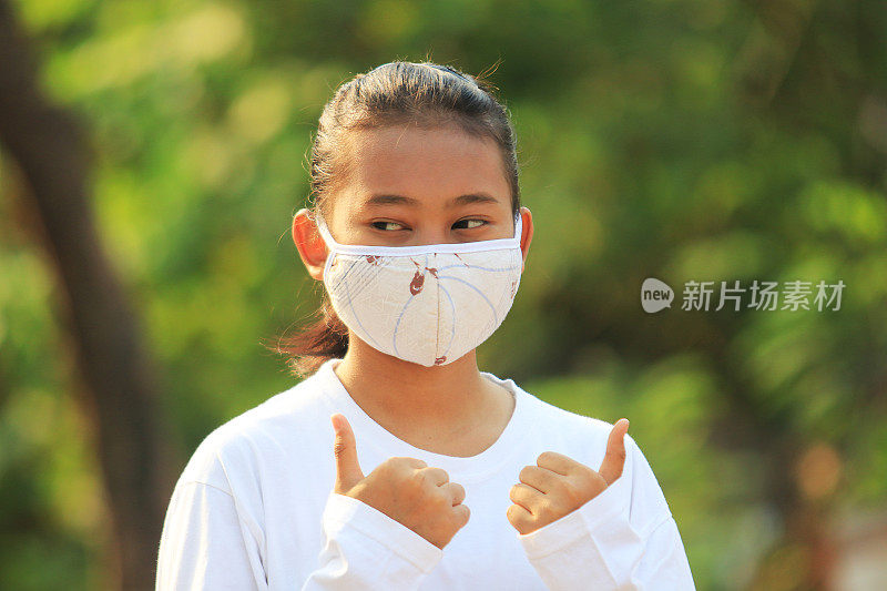 一名少女在冠状病毒大流行期间戴着面具微笑