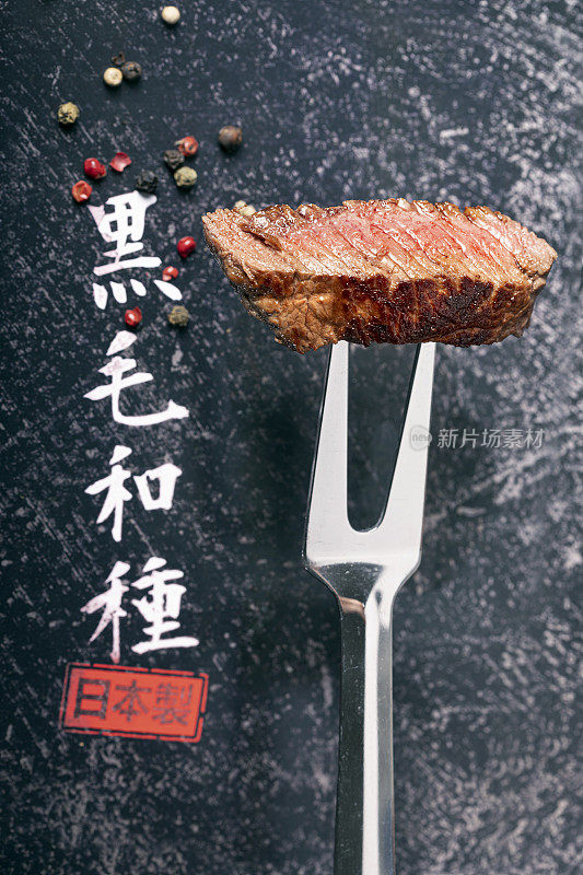 刀叉上烤的神户牛肉，黑色上有日文