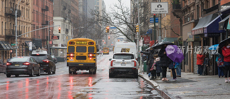 纽约，人们在雨中等公共汽车，其他人在打出租车