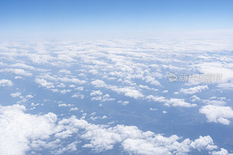 透过飞机窗口观看蓝天、白云和地面风景