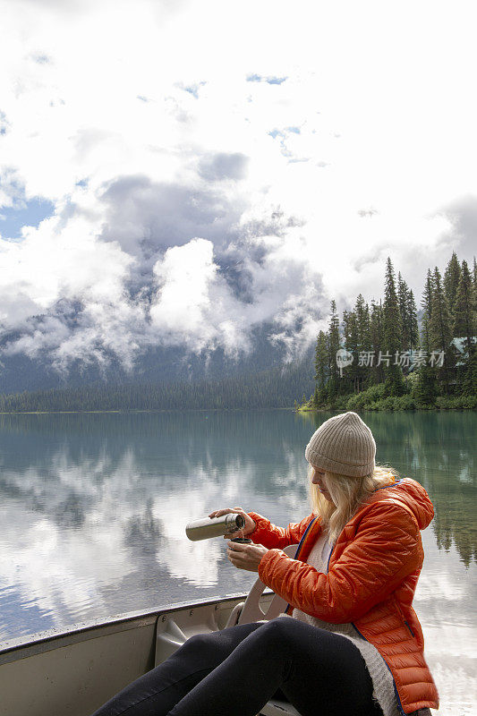 女人喜欢在高山湖的船上喝热饮