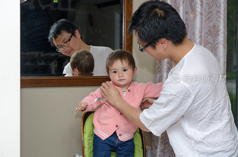 一位中国父亲在晚饭后清理他的混血女婴
