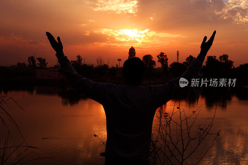 年轻男子向上帝祈祷的剪影