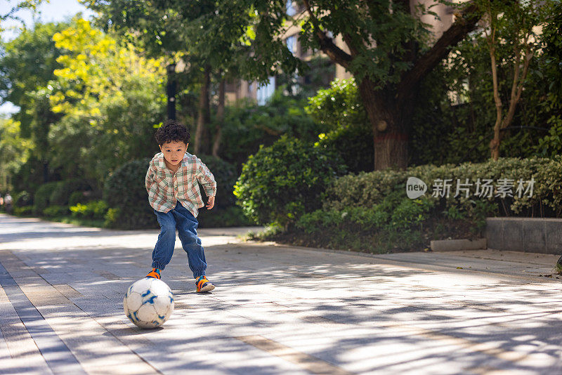 一个小男孩在院子里踢足球