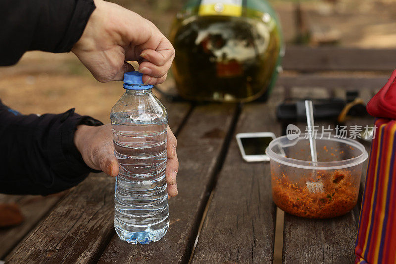 骑摩托车旅行的人在休息时喝水