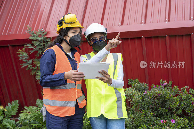 两个拉丁女人在施工的过程中，他们领导观察计划