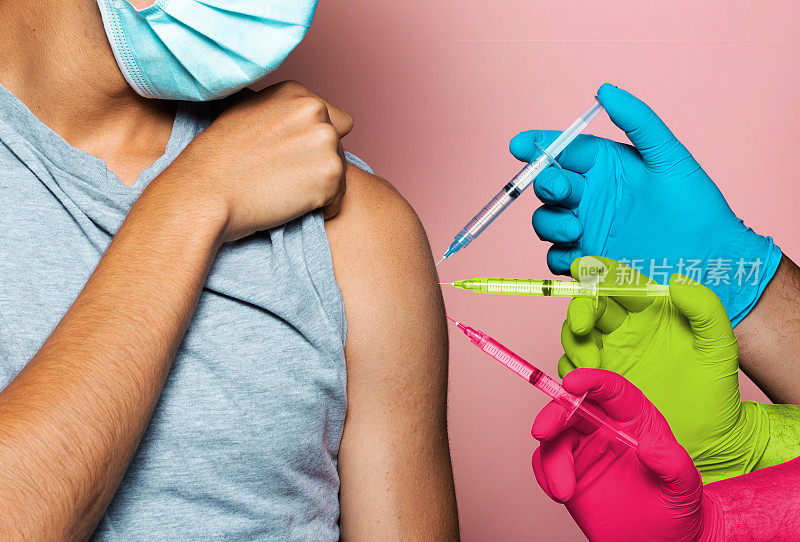 一名年轻男子接种了三剂疫苗，包括第三剂加强剂，疫苗接种概念，粉色背景