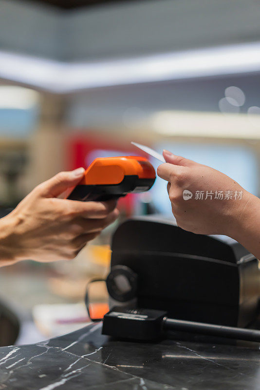 服务员用接触式读卡器刷顾客的信用卡结账