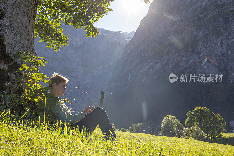 一个年轻人在树下的草地上休息