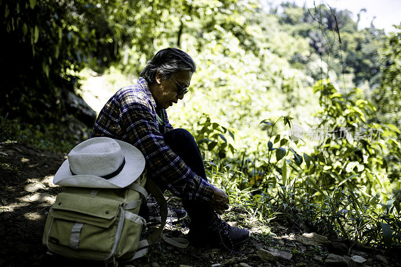 肖像高级男子是绑海岸徒步旅行在森林