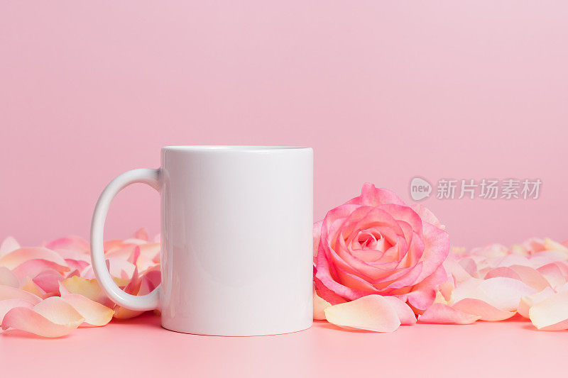 Mockup马克杯与玫瑰和花瓣粉红色的背景，咖啡杯或马克杯的模板