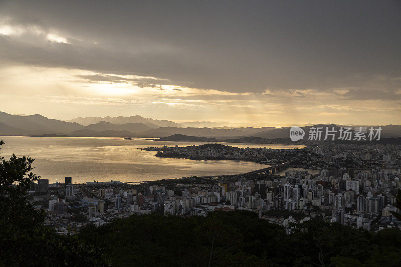 大城市傍晚的全景，海湾和大海在引人注目的天空和云彩中