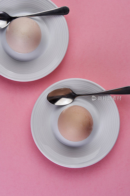 鸡蛋站在鸡蛋杯在粉红色的背景