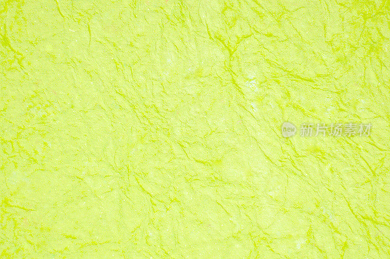水平空光石灰绿色明亮充满活力的霓虹灯颜色的垃圾纹理污浊皱褶的纸一样的纹理和褶皱的抽象背景