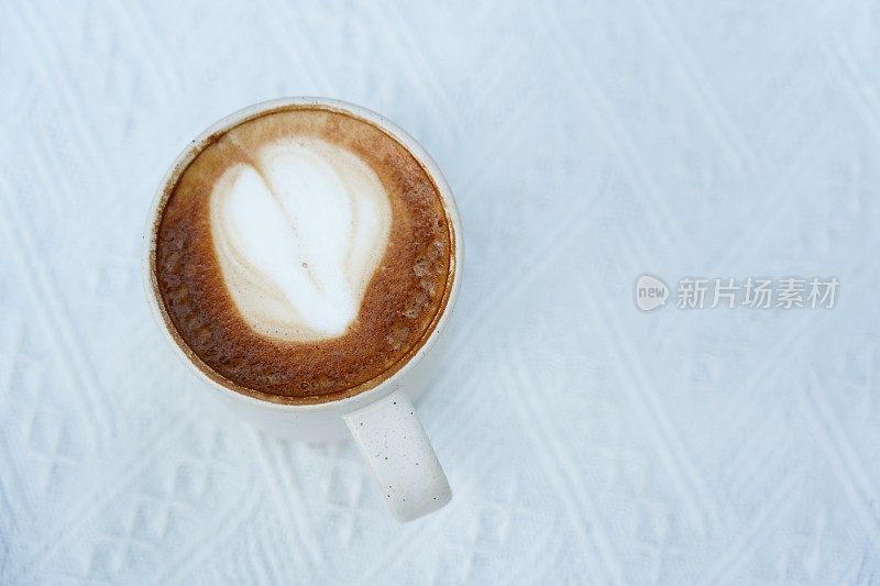 一杯带有心形拉花图案的热拿铁咖啡