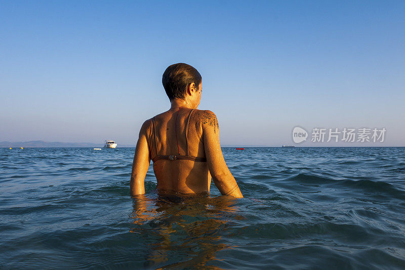 美丽的女人在海里游泳