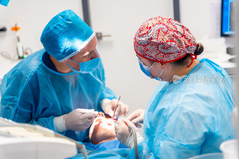 两个女医生在做口腔手术，牙医在做手术