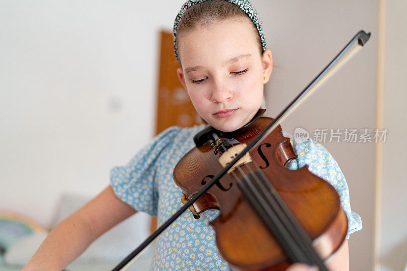 十几岁的女孩在家里拉小提琴