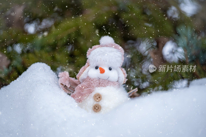 靠近可爱的雪人玩具在雪地上。