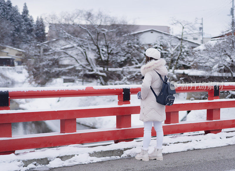 美丽的女子游客享受他们的日本之旅在雪的冬天。