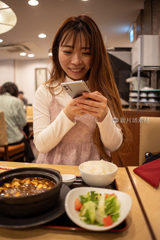 妇女在吃午饭前给食物拍照