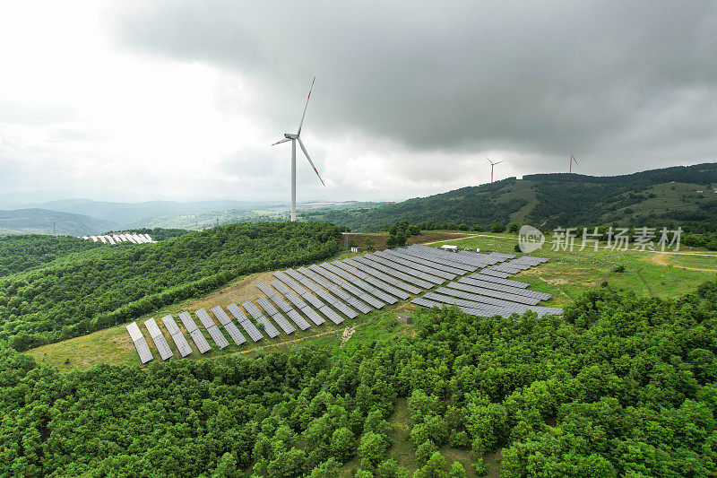 森林地区的太阳能电池板和风力涡轮机。可再生能源